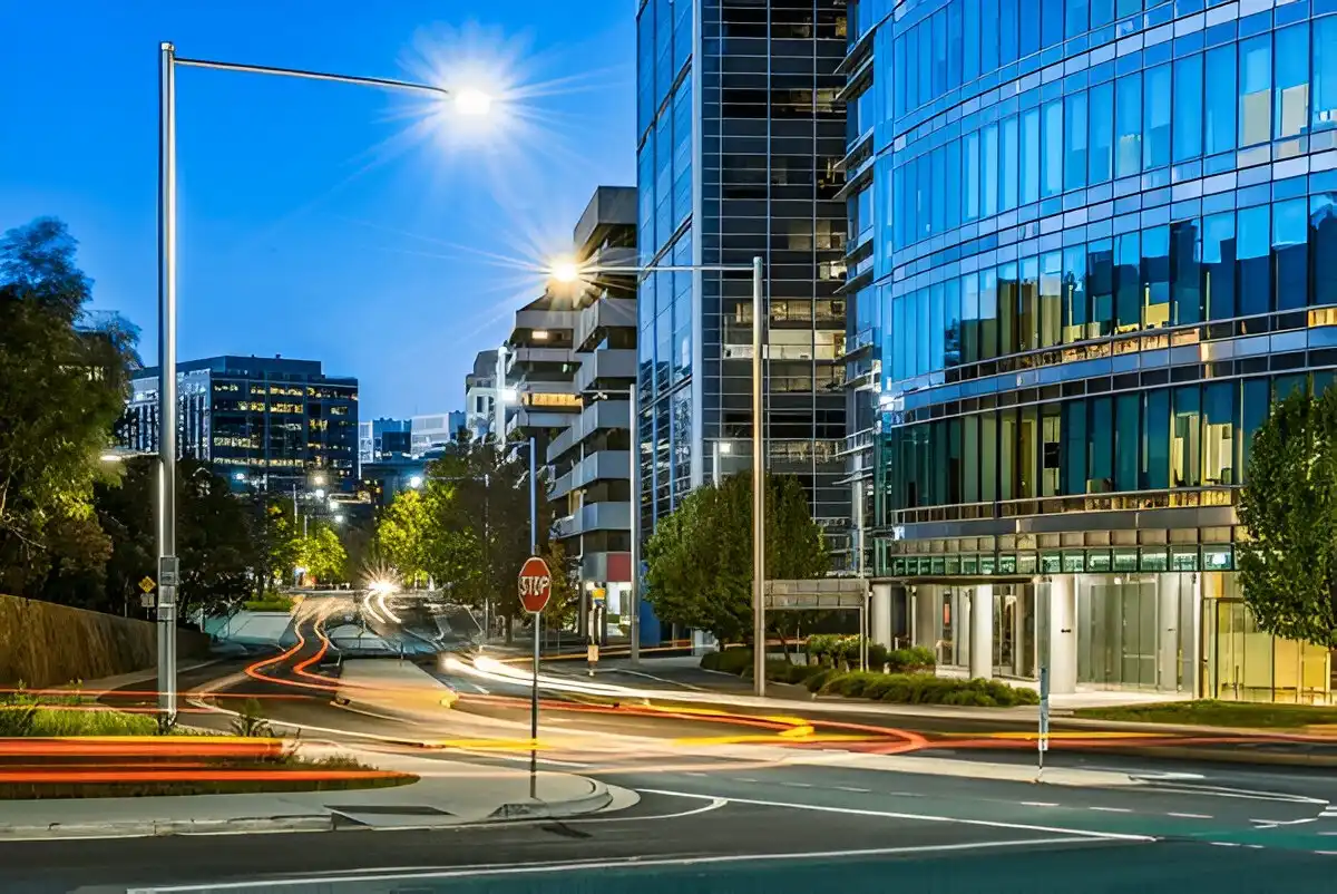 Removalists Canberra 4 Modern Canberra city street at dusk with glass office buildings, street lights, and car trails.